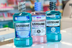 three bottles of Listerine mouthwash on a store counter