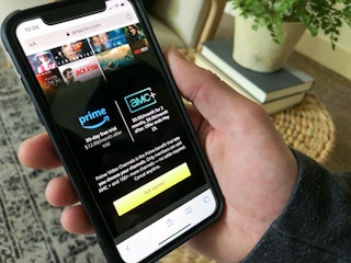 person holding phone with AMC plus offer displayed