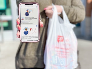 woman holding cellphone with donate rewards page on app 