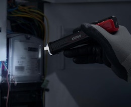 a person using a voltage tester on a fuse box