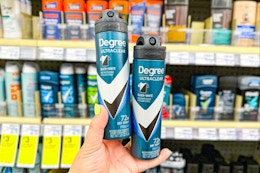 person holding 2 degree dry spray deodorants