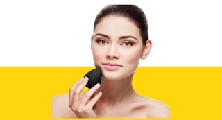 a woman using a makeup sponge