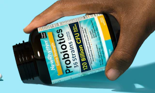 a hand holding a bottle of probiotics supplements 