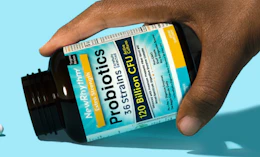 a hand holding a bottle of probiotics supplements