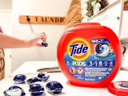 Person throwing tide pod into their washer