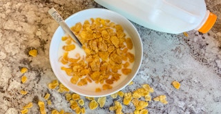 a bowl of cereal with a milk jug
