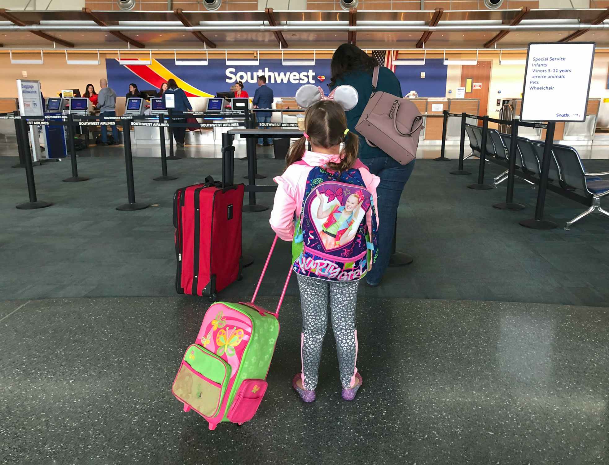 young girl with Jojo Siwa bag in Southwest airport check-in