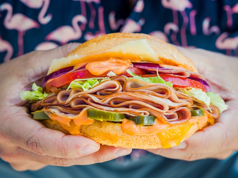 person holding a sandwich from schlotzskys deli