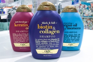 three bottles of ogx shampoo on a white counter