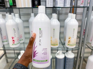 someone holding a liter-sized biolage shampoo