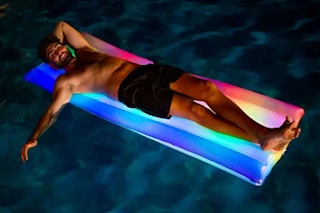 man floating on a pool float with led lights