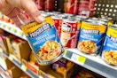 hand holding progresso soup next to store shelf