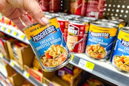 hand holding progresso soup next to store shelf