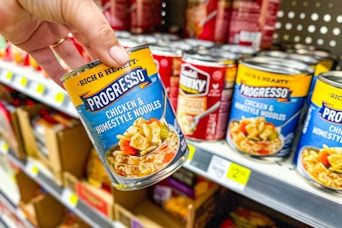 hand holding progresso soup next to store shelf