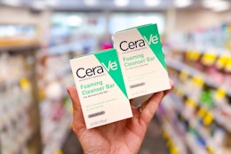 person holding 2 cerave cleansing bars in an aisle