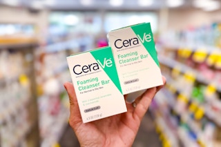 person holding 2 cerave cleansing bars in an aisle