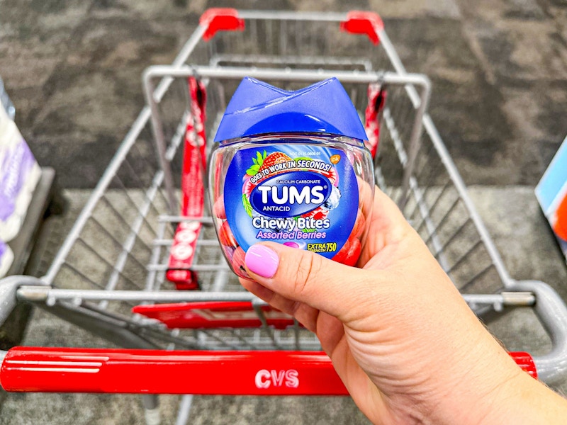 person holding tums chewy bites over a cvs cart