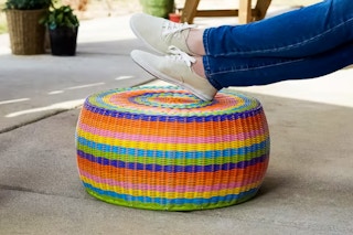Lifestyle image of the Household Essentials Wicker Storage Ottoman in multicolor (close up shot of someone resting their feet)