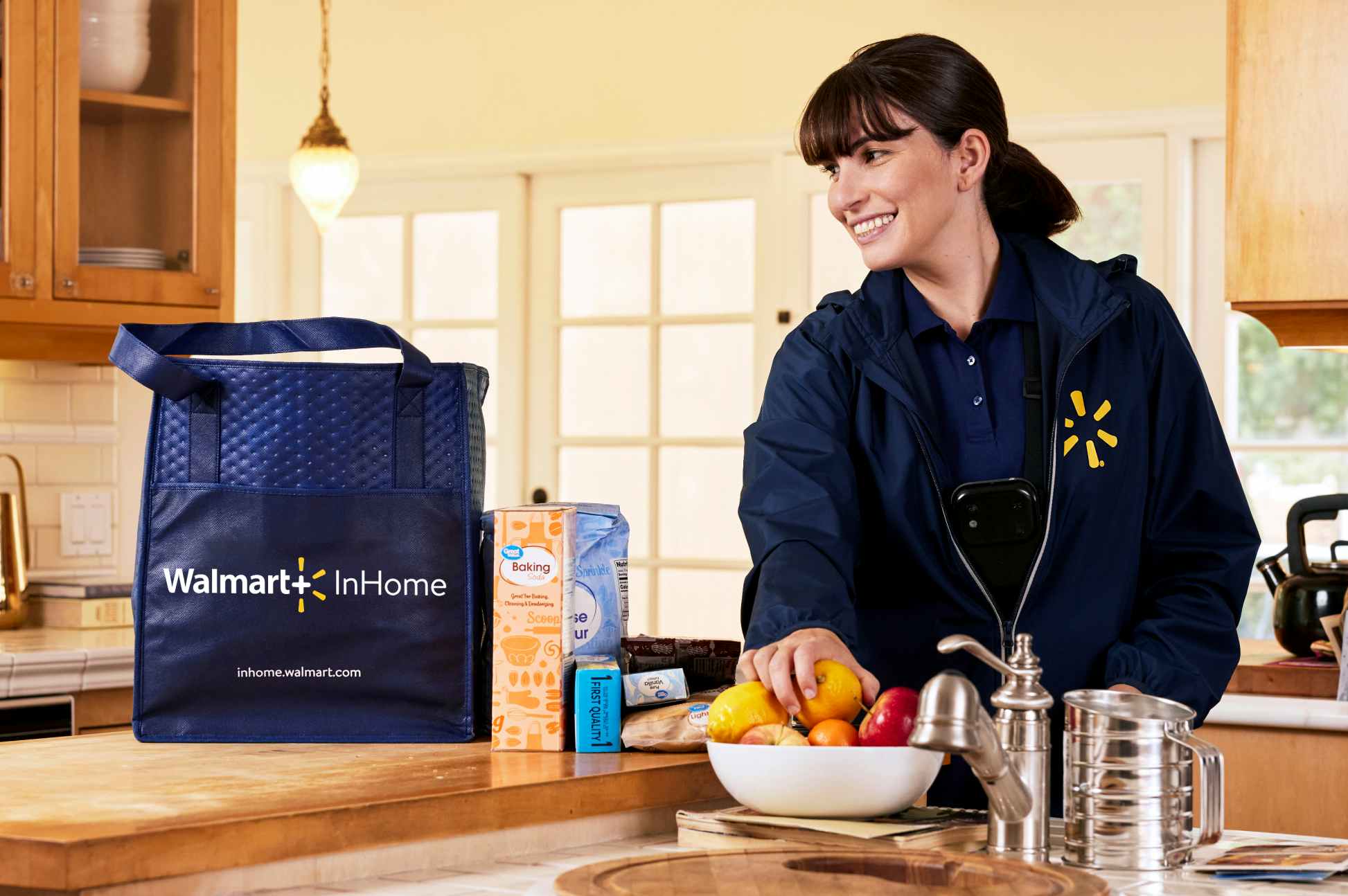 walmart employee delivering fruit and baking goods into home with walmart inhome