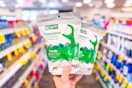 person holding 2 packages of flossers in an aisle