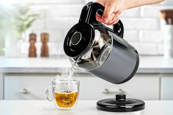Lifestyle image of the Tinana glass electric kettle being used to make a cup of tea