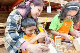 a mom and her kids at home depot doing a kids workshop activity
