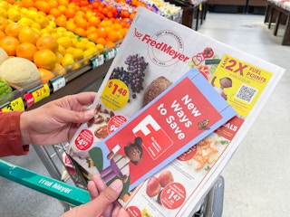 a person holding a fred meyer rewards brochure