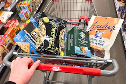 person pushing a cart with archer jerky, wonderful pistachios, kind bars, and more snacks