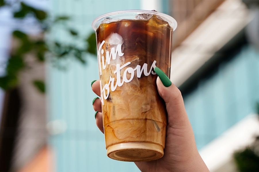 someone holding a Tim Hortons coffee