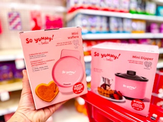 hand holding a bella waffle maker in front of a target cart