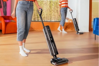 a person using a wet.dry vacuum on hardwood floors