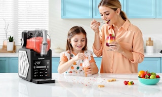 a mom and daughter eating ice cream next to a slushie machine
