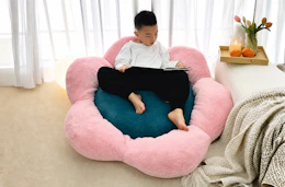Lifestyle image of a kid on a flower-shaped bean bag cushion