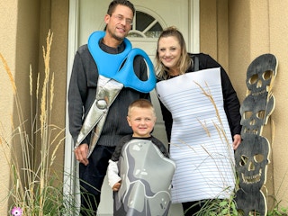 a family in a rock paper scissor costume in front of house door 