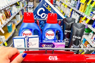 person pushing a cart with cottonelle toilet paper, persil detergent, secret deodorant, crest toothpaste, and axe body wash