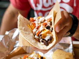 person holding a burrito from moes southwest grill