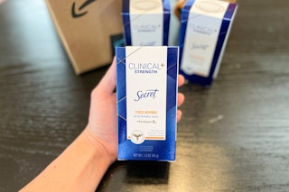 A hand holding Secret clinical deodorant
