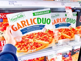 hand holding a freschetta garlic duo pizza in front of a target shelf
