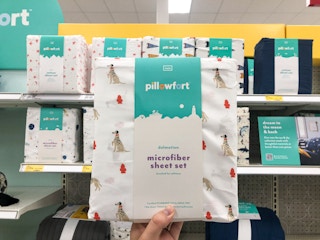 hand holding sheet set in front of Target store shelf