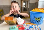 a child eating a mcdonalds kids meal with a Boo Bucket