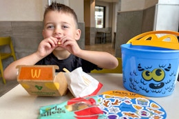 a child eating a mcdonalds kids meal with a Boo Bucket