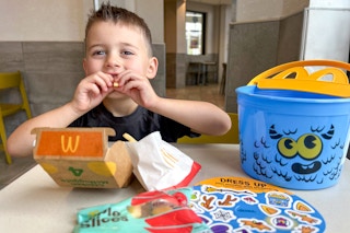 a child eating a mcdonalds kids meal with a Boo Bucket