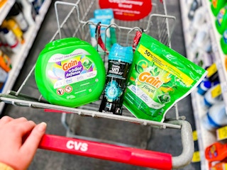 person pushing cart with Gain and Downy laundry products inside