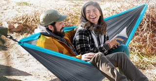 two people sitting in a blue and grey hammock
