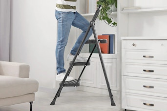 Lifestyle image (close up shot) of person using the ladder in home setting (bookshelf) 