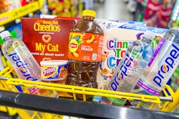 cheerios, cinnamon toast crunch, propel, fritos, lipton products in a yellow shopping cart
