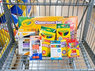 Crayola, BIC, CraZArt, Pen+Gear, and Elmer's school supplies in a Walmart shopping cart.