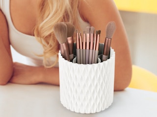 a white makeup brush holder on a table