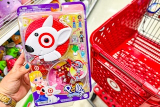 hand holding a polly pocket bulleye playset in front of a target cart
