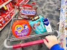 snickers candy, tide pods, maybelline eyeshadow, pampers baby wipes, and crest gum toothpaste in a cart